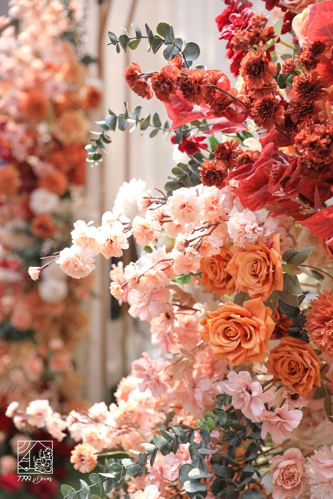 Cổng hoa đám cưới kim loại ánh vàng và gam hoa đỏ và cam cháy