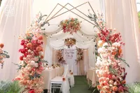 Cổng hoa đám cưới kim loại ánh vàng và gam hoa đỏ và cam cháy